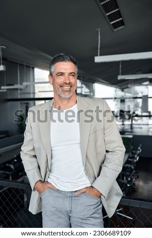 Happy proud mid aged mature professional business man ceo executive wearing suit standing in office looking away thinking of success, enjoying leadership, corporate growth. Vertical Royalty-Free Stock Photo #2306689109