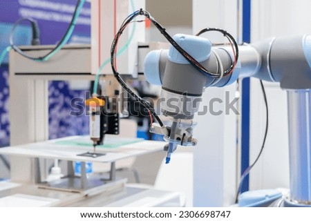 Pick and place robotic arm manipulator during work at modern robot exhibition, trade show, factory, plant - close up view. Industrial, manufacturing, engineering and automated technology concept Royalty-Free Stock Photo #2306698747