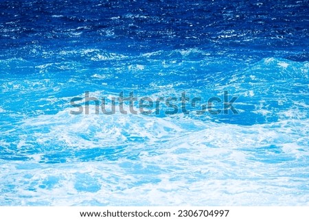 The sea as a background. Waves and sea foam. Water color gradient. Nature photo for design and background.