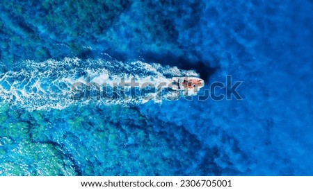 A fast boat on an azure sea. Clear turquoise water and a boat. View from the air. Summer landscape from a drone. Rest and travel in the summer time. The season for vacation. Photography for design.