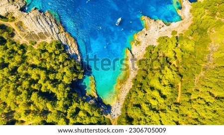 A sea bay. Clear turquoise water and a boat. View from the air. Summer landscape from a drone. Rest and travel in the summer time. The season for vacation. Photography for design.