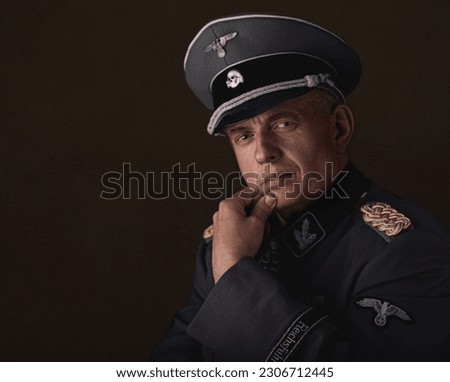 Man dressed in Waffen SS uniform in a cap reenacting Royalty-Free Stock Photo #2306712445
