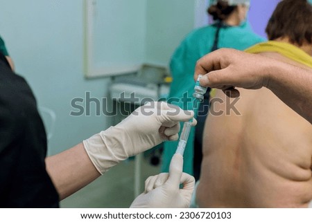 During surgical preparations doctor administers epidural spinal anesthesia injections to provide pain relief numbness in lower body