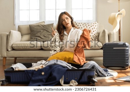 Portrait of backpacker beauty asian traveler woman packing prepare stuff and outfit clothes in suitcases travel bag luggage for summer, holiday, weekend, tourist, journey, vacation trip at home.travel Royalty-Free Stock Photo #2306726431