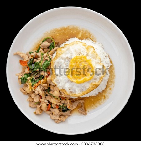 Khao Pad Ka Prao Gai Kai Dao, Thai food, streamed rice topped with basil stir fried chicken and fried egg in ceramic plate isolated on black background, square ratio