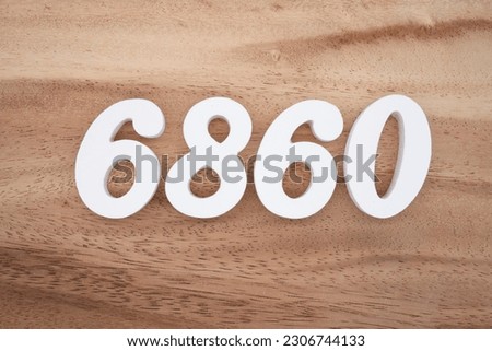 White number 6860 on a brown and light brown wooden background.