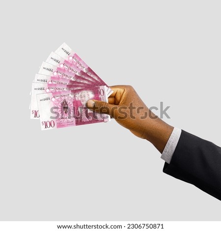 Black hand with suit holding 3D rendered Tongan Paʻanga notes isolated on white background