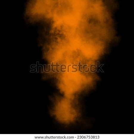 Orange color powder explosion isolated on black background. Royalty high-quality stock photo image Freeze motion orange powder exploding. Colorful dust explode. Paint Holi, dust particles splash