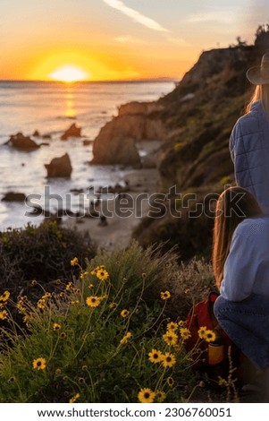 Rear view of young women watching sunset up in the hills in El Matador Beach, Malibu, California Royalty-Free Stock Photo #2306760051