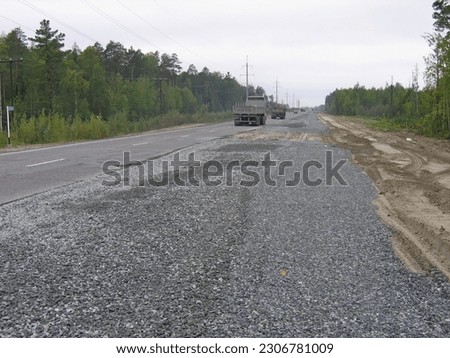 repair of the roadside near the new asphalt road against the background of the blue sky