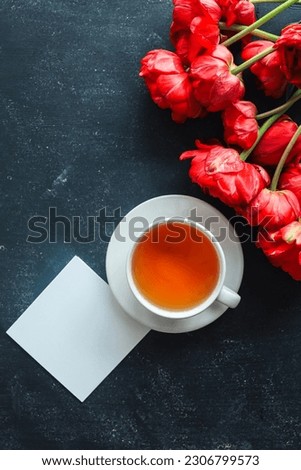 Greeting card with place for your text, cup of tea and spring flowers top view.