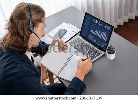 Male customer service operator or telesales agent sitting at desk in office, wearing headset and prepare making sales, BI data analysis dashboard on laptop screen. Call center portrait. Entity