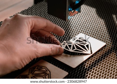 Laser engraving and cutting, woman holding an example of a cut out wooden heart Royalty-Free Stock Photo #2306828947