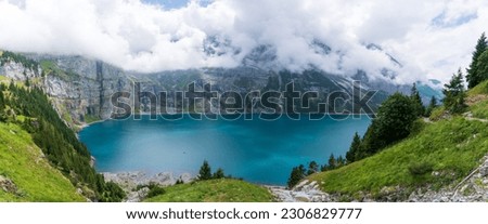 Amazing tourquise Oeschinnensee with waterfalls and Swiss Alps, Kandersteg, Berner Oberland, Switzerland. Royalty-Free Stock Photo #2306829777