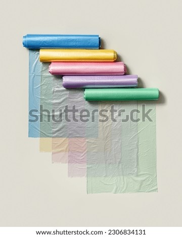 Set colored plastic bags in rolls as flat lay pattern. Bright colorful polyethylene packets for food, beige background. Many new clear disposable polythene bags. Not eco friendly consumption, top view