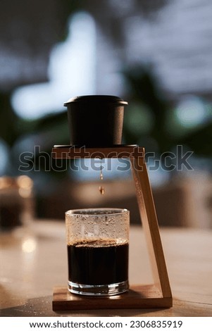 Phin filter for making Vietnamese style coffee on table in coffeeshop Royalty-Free Stock Photo #2306835919
