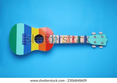 Colorful ukulele on light blue background, top view. String musical instrument Royalty-Free Stock Photo #2306848609