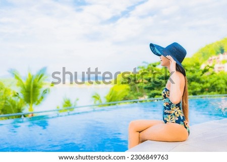 Portrait beautiful young asian woman relax smile leisure around outdoor swimming pool with sea ocean view for travel vacation