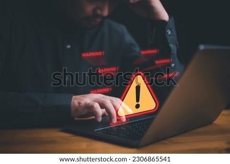 Businessman or it staffs, programmer, developer using computer laptop with triangle caution warning sign for notification error and maintenance concept. Hack system alert, warning computer system