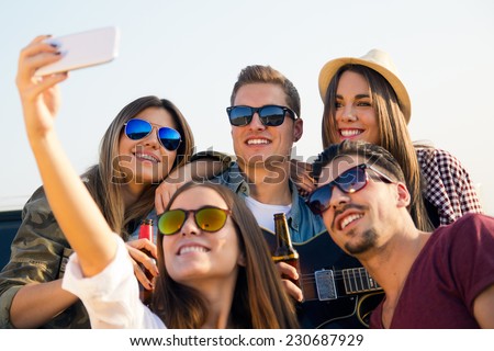 Portrait of group of friends taking a selfie with smartphone. 