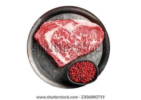 Raw wagyu rib eye beef meat steak in steel tray. Isolated on white background Royalty-Free Stock Photo #2306880719