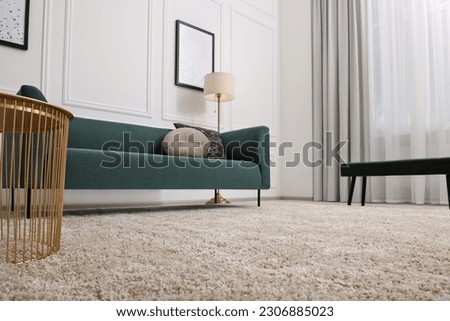 Stylish living room with soft beige carpet, coffee table and sofa, low angle view. Interior design Royalty-Free Stock Photo #2306885023