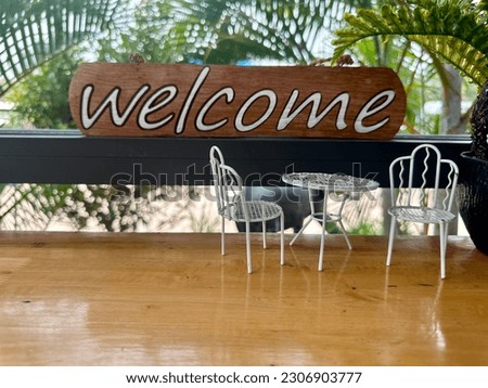 A welcome sign is placed in front of a storefront.