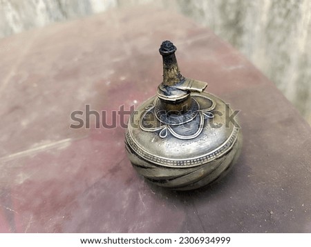 A kerosene lantern is placed on a marble table with a beautiful background. 

