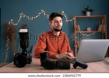 Creative photographer journalist working at home with laptop editing photos. Copy space