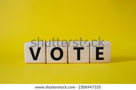 Vote symbol. Concept word Vote on wooden cubes. Beautiful yellow background. Business and Vote concept. Copy space.