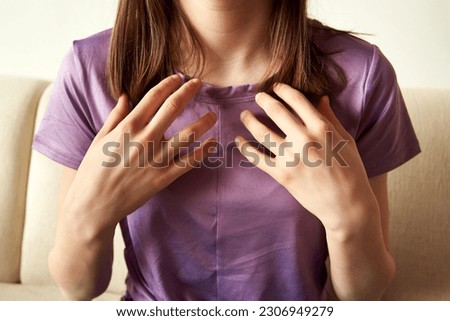 Teenage girl practicing EFT or emotional freedom technique - tapping on the collarbone point Royalty-Free Stock Photo #2306949279