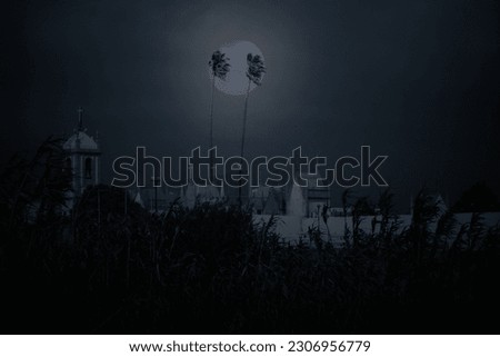 Conceptual image about life and death seeing old European cemetery, church and two tropical palm trees in an overcast full moon night