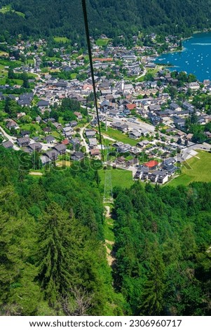 View of Sankt St. Gilgen village, Wolfgangsee Lake and the Alps mountains while going up with Zwolferhorn cable car. Spectacular view of a rural and wild breathtaking nature in Austria. 