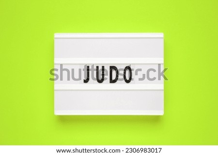 The word judo on lightbox isolated green background.