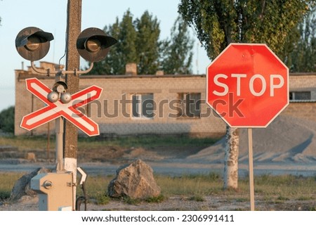 STOP sign near the railway crossing. Rules of the road. Level crossing sign. Caution sign about hazard and train track