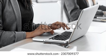 Shot of two business women work with laptops on the partitioned desk in the coworking space. Concept of social distancing. Royalty-Free Stock Photo #2307009377