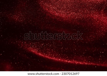 Glittering flows of gold particles in fluid. Various stains and overflows of golden dust particles in liquid with yellow tints. Magic Galaxy of golden dust particles in red fluid. Royalty-Free Stock Photo #2307012697