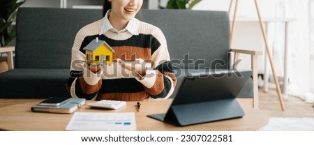 Real estate broker agent presenting and consult to customer to decision making sign insurance form agreement, home model, concerning mortgage loan offer in home office