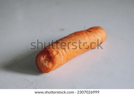 Piece of carrot lies on white table