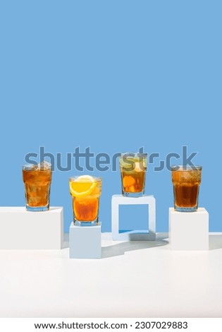 Various Tea Drinks are in one frame, There are iced tea, sweet iced, lemon, and lychee tea in a glass with a blue background
