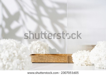 Cosmetics skin care product presentation scene made with empty wooden tray and white flowers on bathroom shelf. Studio photography.