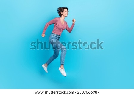 Full size profile photo of crazy active girl jumping run empty space ad isolated on blue color background