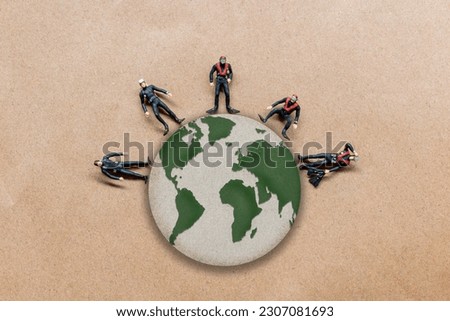 Miniature people standing on the globe with paper background , World Population Day concept