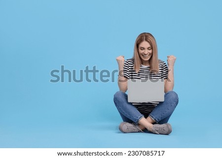 Emotional woman with laptop on light blue background. Space for text