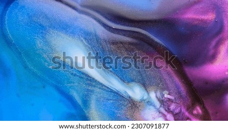 Blue purple liquid abstract background. Slow motion fluid art splash. Brilliant blue lilac paint spreads sparkling with glitter. Golden particles sparkle in colorful blue-purple watercolor backdrop