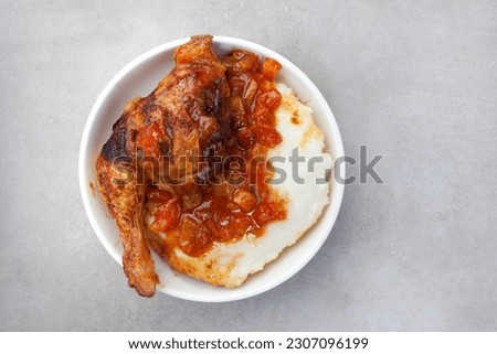 Traditional chicken and pap, south African style. Flat lay on grey Royalty-Free Stock Photo #2307096199