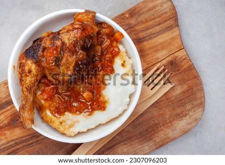 Traditional chicken and pap, south African style. Flat lay on grey Royalty-Free Stock Photo #2307096203