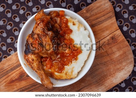 Traditional chicken and pap, south African style. Flat lay on wood with unique African printed fabric

 Royalty-Free Stock Photo #2307096639
