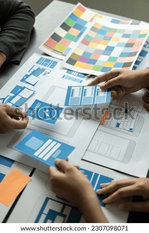 Frontend developer team brainstorms UI and UX design ideas for mobile apps on paper wireframe interfaces. Planning a user interface development team for design Website on smartphone portrait image