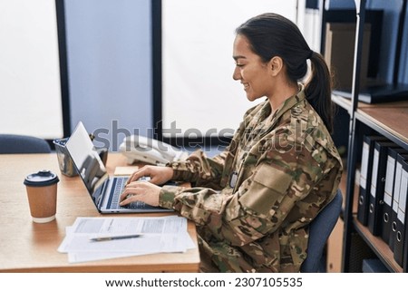 Young hispanic woman army soldier using laptop at office